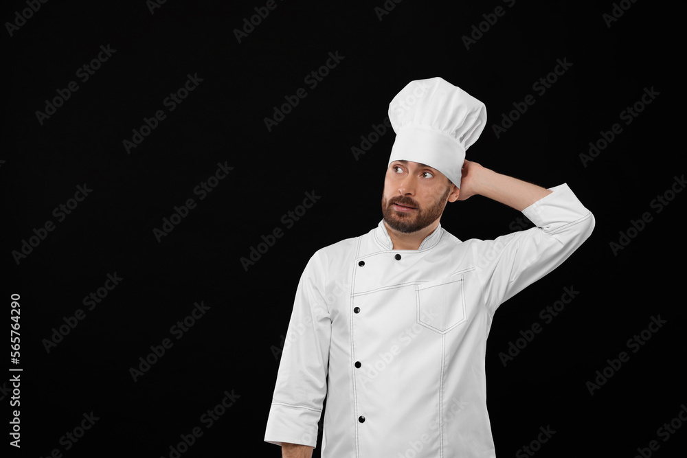 Thoughtful mature chef on black background, space for text