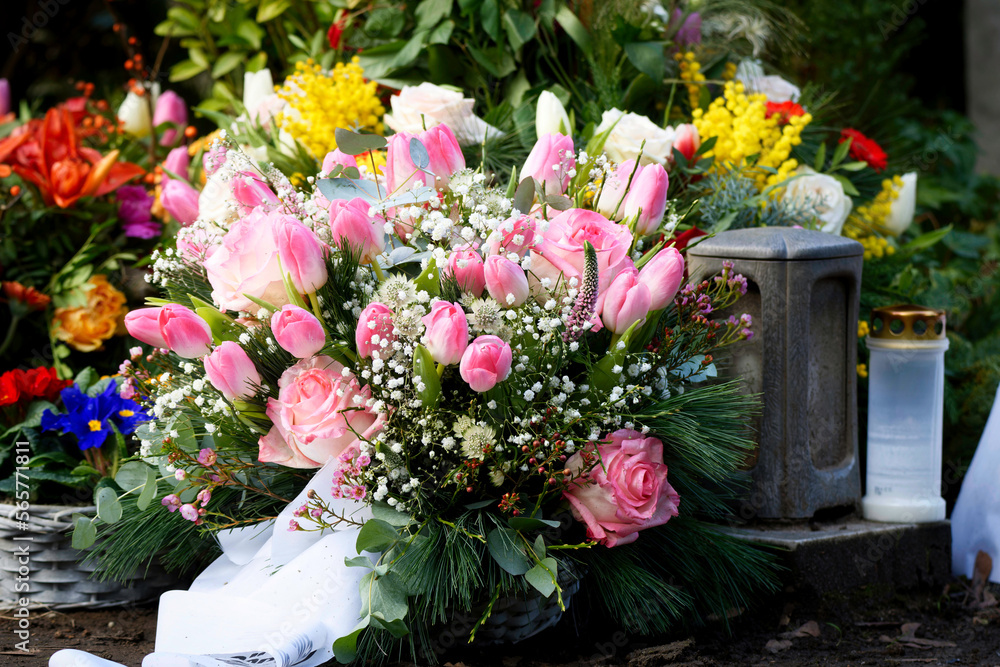 pink tulips and roses on a grave after a funeral