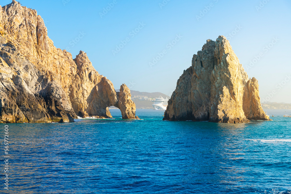 A cruise ship is in view behind the famous El Arch, the Arch, at the Land's End region on the Baja Peninsula at Cabo San Lucas, Mexico.