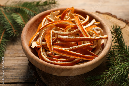 Dry orange peels and fir branches on wooden table  closeup