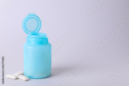 Jar with chewing gums on light grey background. Space for text