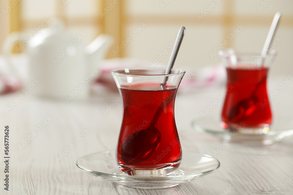 Glasses of traditional Turkish tea on white wooden table indoors Glasses of traditional Turkish tea on white wooden table indoors