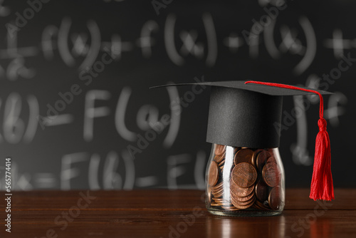 Wallpaper Mural Scholarship concept. Graduation cap and jar with coins on wooden table, space for text Torontodigital.ca
