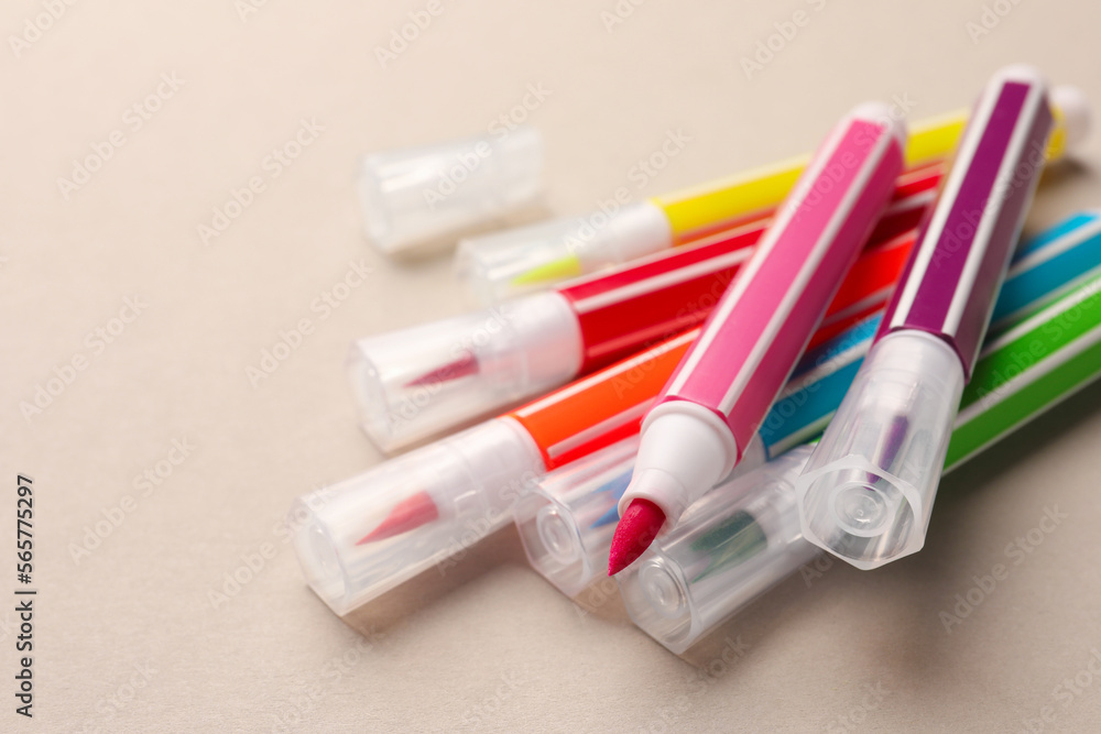 Many bright markers on light grey background, closeup. Space for text