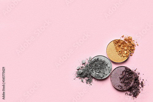 Different crushed eye shadows on pink background, flat lay. Space for text