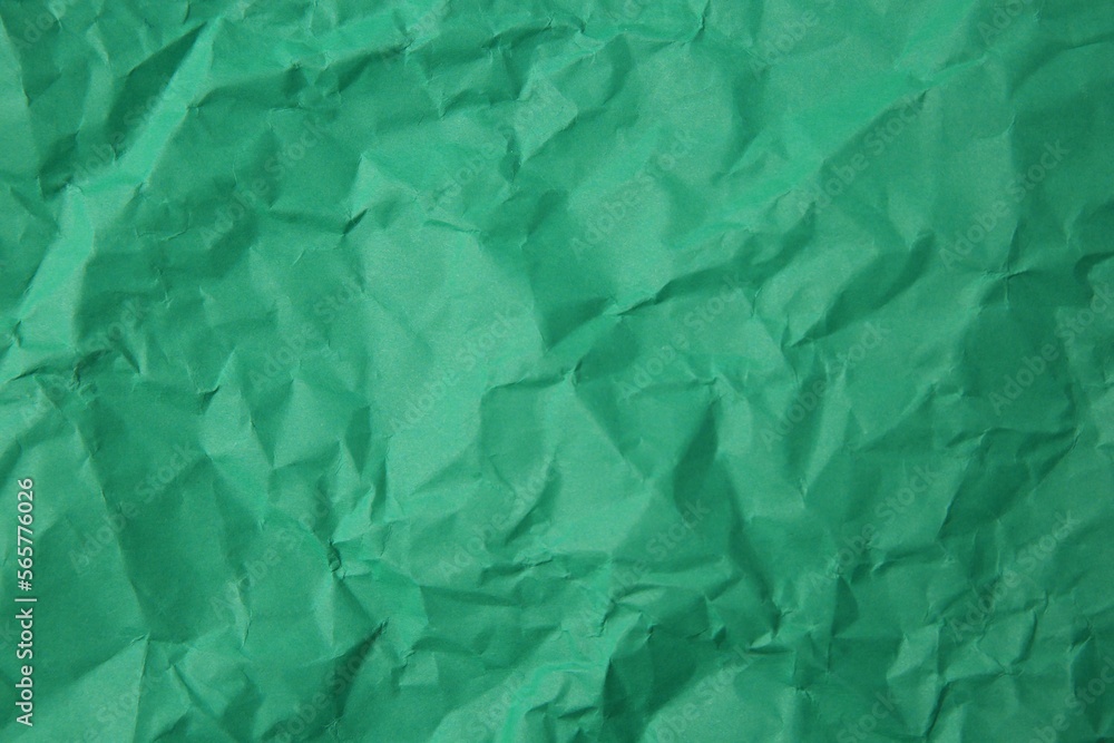 Sheet of crumpled green paper as background, top view