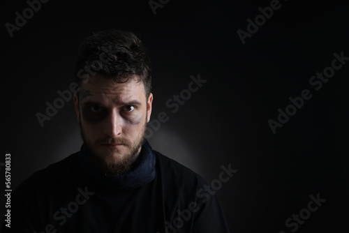 Quadro em tela Man with bruise on dark background, space for text. Hostage