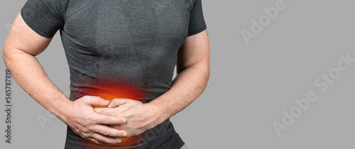 Abdominal Pain. Man touching stomach painful suffering from stomachache causes gastric ulcer, appendicitis or gastrointestinal system disease. photo