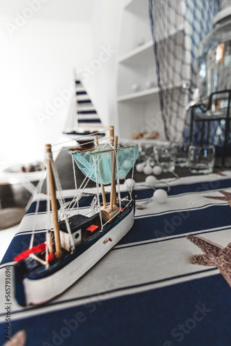 Barca de artesania en miniatura en cuarto ordenado con articulos de navegacion, mar y pesca