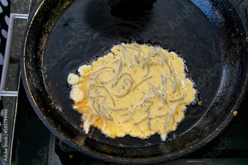A whitebait pattie being cooked on a market stall ready to make a whitebait sammy. photo