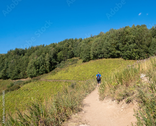 Tourists with a backpack goes along a mountain path. Active lifestyle walking in the mountains with a backpack.
