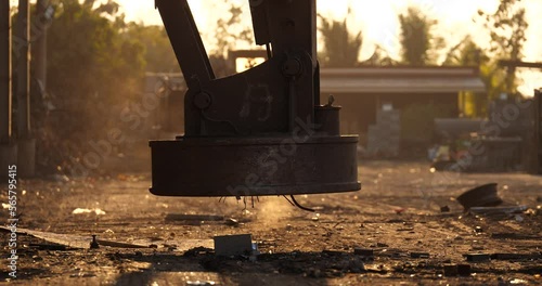 Backhoe is using electromagnets crane, electromagnets crane picking up scrap metal in a recycling plant,Environment and save the world concept. photo