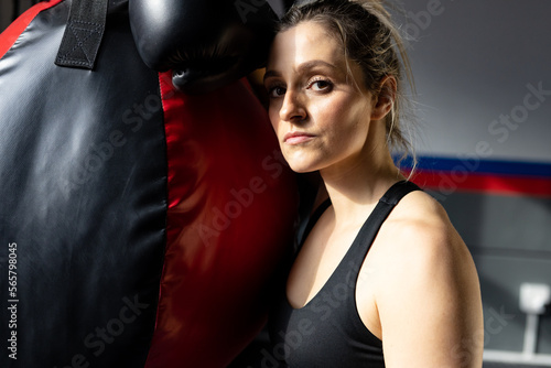 Portrait of caucasian sports woman with boxing bag at gym photo