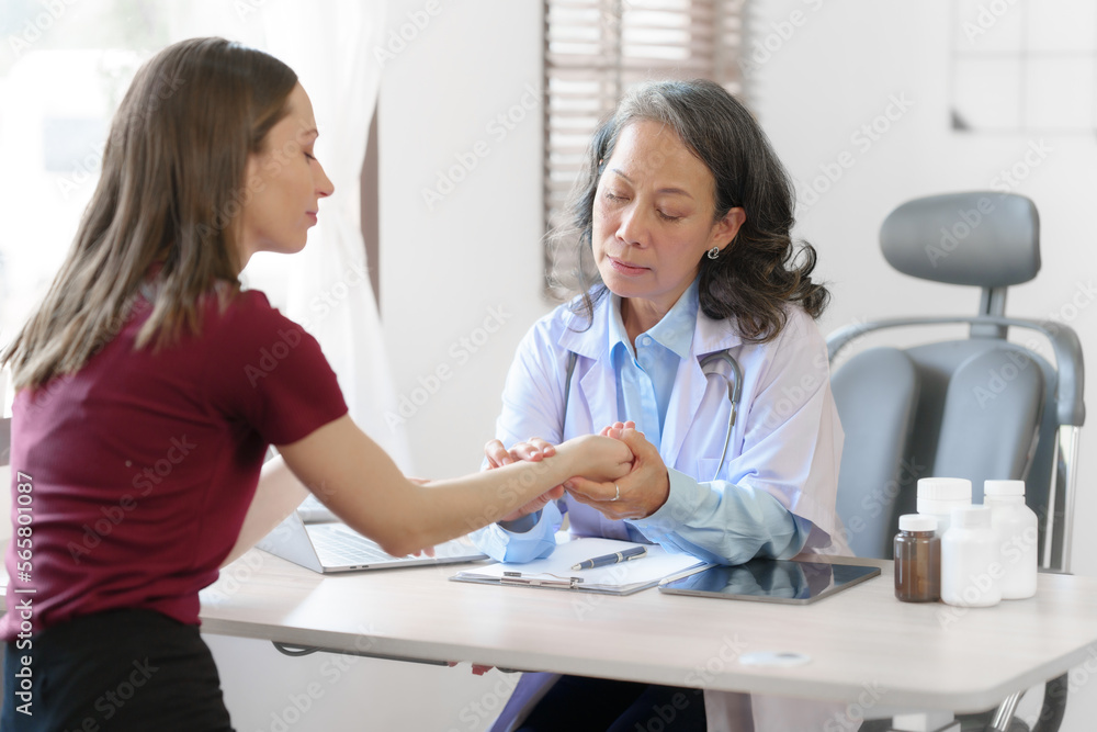 Fototapeta premium Elderly Asian female nurses instruct caucasian patients with orthopedics and educate them on orthopedic care or take pulse to check heart rate per minute. to look for abnormal symptoms