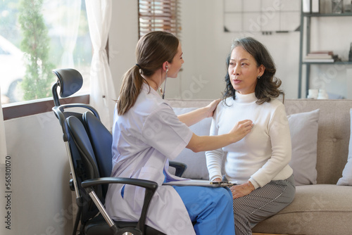 Caucasian female nurse using stethoscope to listen heartbeat of elderly patient, young Asian woman to detect abnormal heart rates from insufficient rest