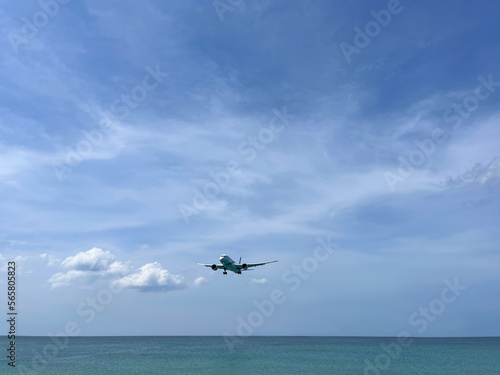 Plane flies low above the sea. Picturesque photo. Blue sky with clouds. Skyline. Passenger, cargo transportation. Boeing 787-8 aircraft model. Aviation. Airplane in flight. Air transport. Panorama. 