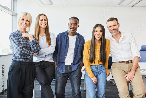 фотографія Group shot of diverse casual business people standing in office smiling at camer