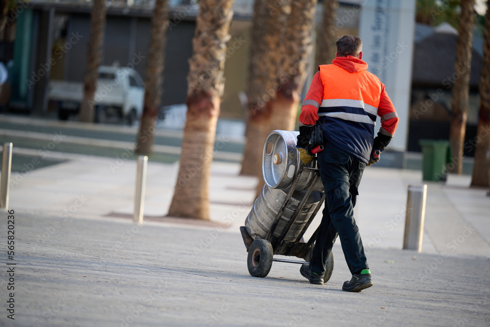 Man delivering beer kegs in Malaga, Spain Man delivering beer kegs in Malaga, Spain
