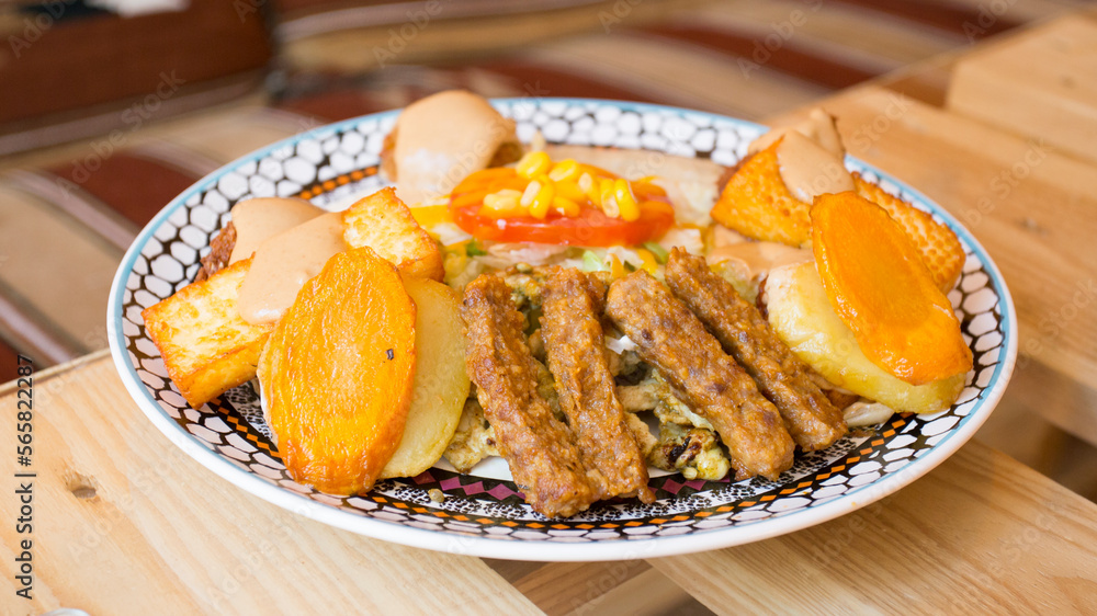 African combo plate with rice, fried cheese, grilled vegetables, peanut sauce and other traditional products.