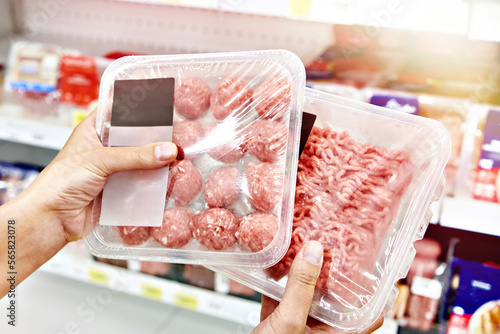 Buyers hands with chopped meat in shop photo