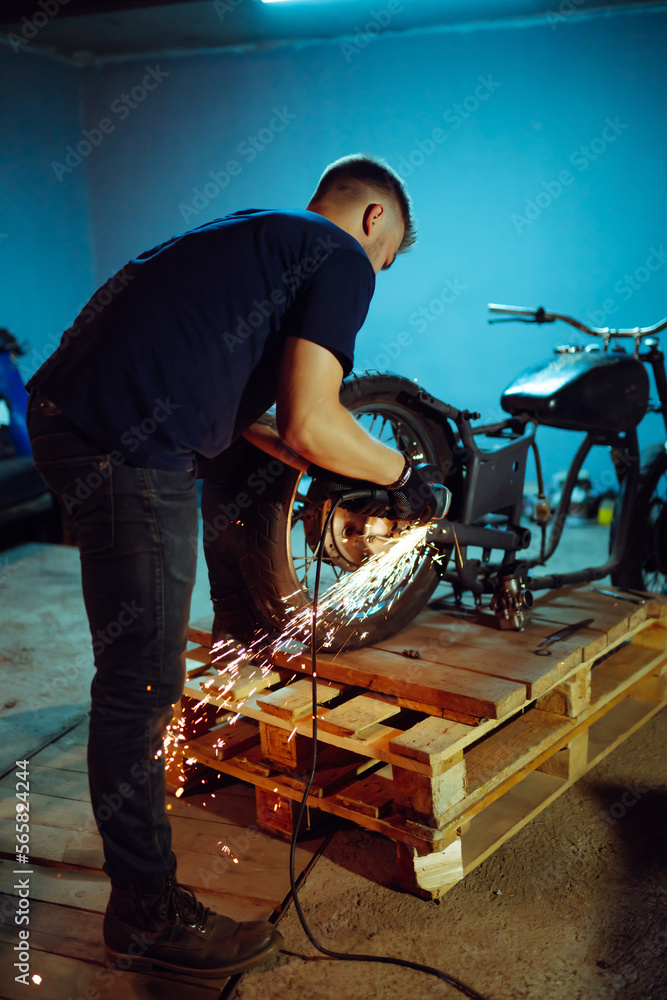 Motorcycle repair. Disassembled motorcycle. The expert works with electric welding of metal. Instruments and equipment. Motorcycle repair. Disassembled motorcycle. The expert works with electric welding of metal. Instruments and equipment.