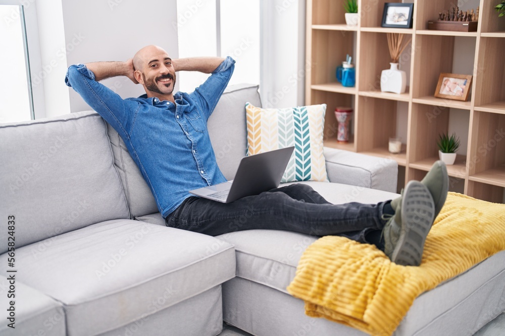 Young hispanic man relaxed with hands on head using laptop at home Young hispanic man relaxed with hands on head using laptop at home