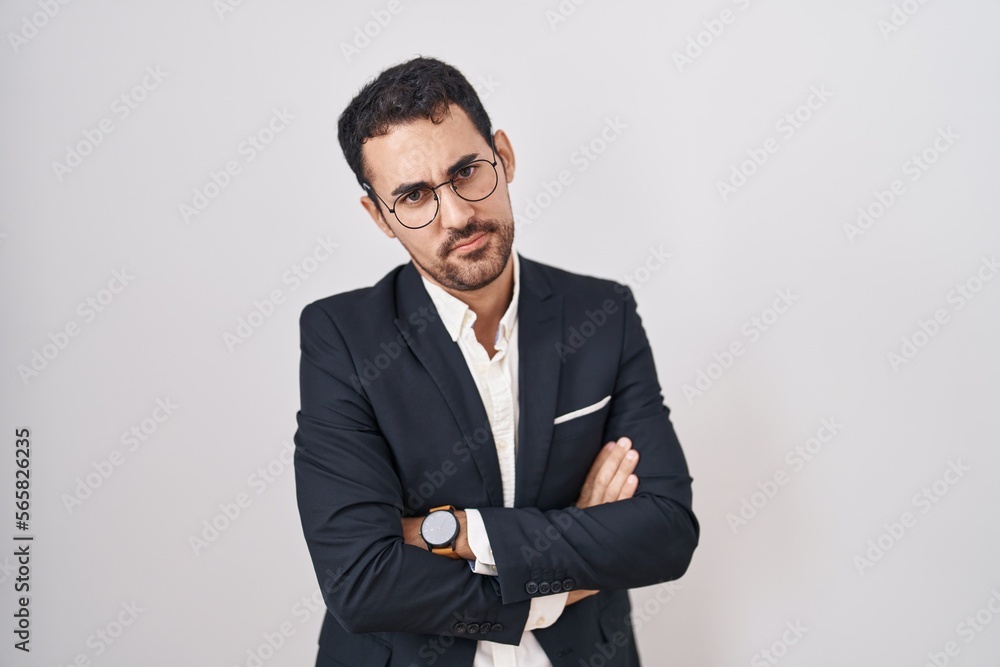 Handsome business hispanic man standing over white background skeptic and nervous, disapproving expression on face with crossed arms. negative person. Handsome business hispanic man standing over white background skeptic and nervous, disapproving expression on face with crossed arms. negative person.