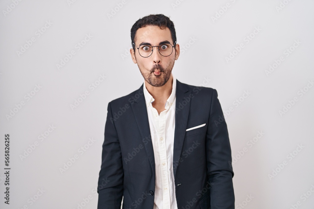 Handsome business hispanic man standing over white background making fish face with lips, crazy and comical gesture. funny expression. Handsome business hispanic man standing over white background making fish face with lips, crazy and comical gesture. funny expression.