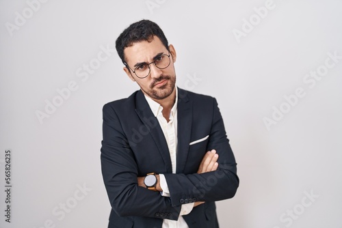 Handsome business hispanic man standing over white background skeptic and nervous, disapproving expression on face with crossed arms. negative person.