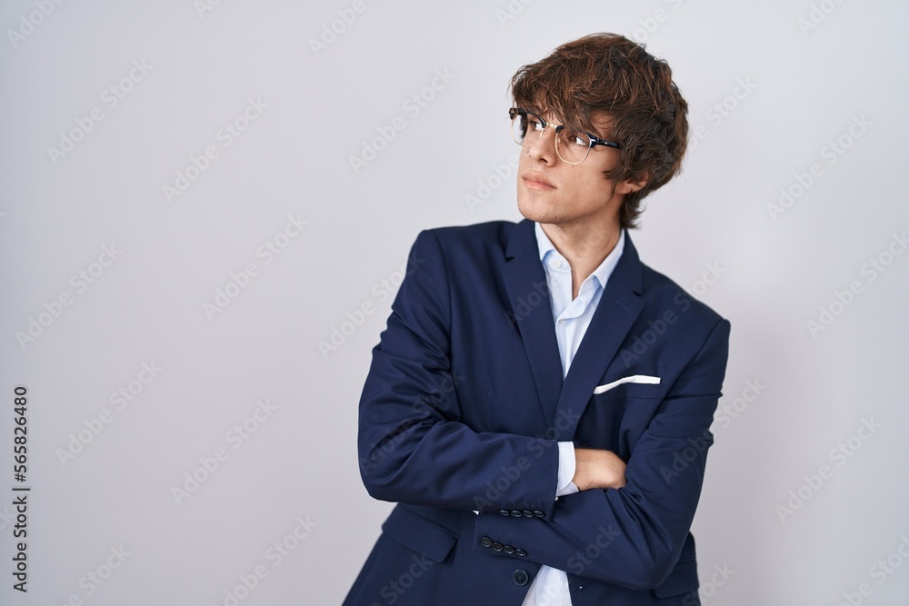 Hispanic business young man wearing glasses looking to the side with arms crossed convinced and confident Hispanic business young man wearing glasses looking to the side with arms crossed convinced and confident