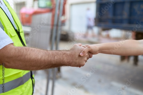 Middle age man architect shake hands at street