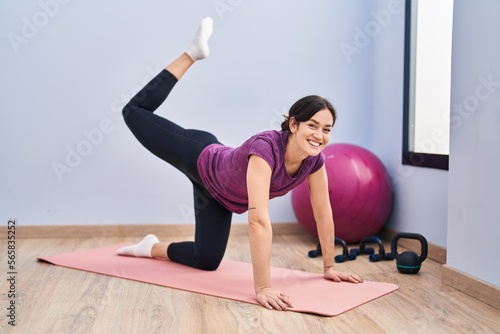 Young woman smiling confident stretching at sport center