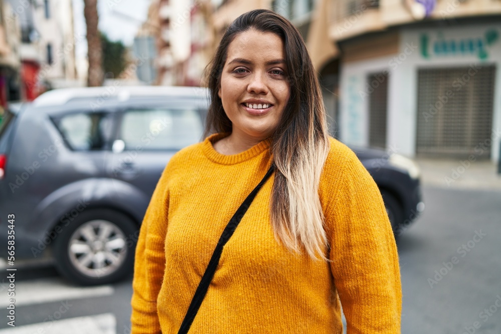 Fototapeta premium Young beautiful plus size woman smiling confident standing at street