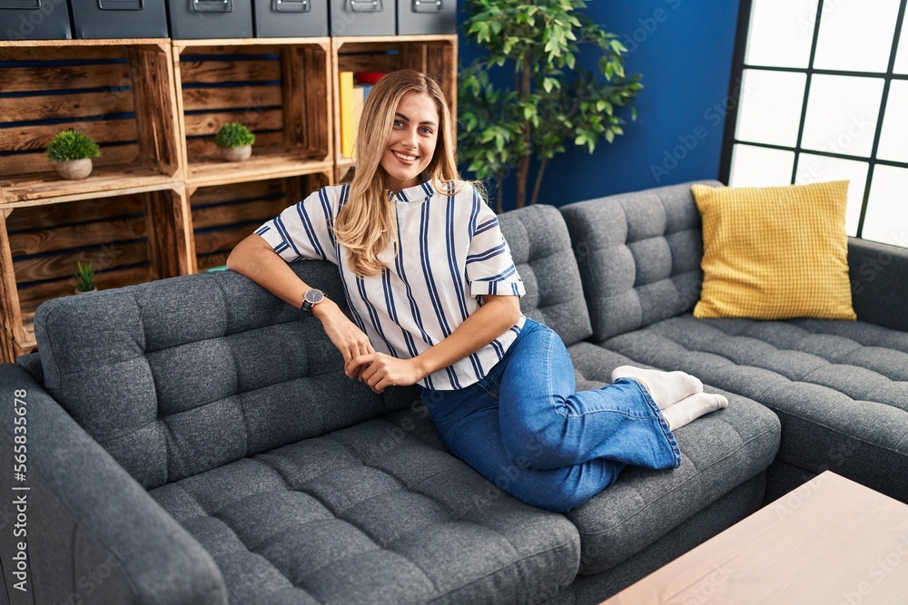Obraz premium Young blonde woman smiling confident sitting on sofa at home
