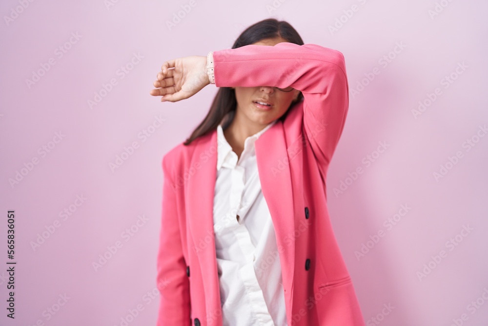 Young hispanic woman wearing business clothes and glasses covering eyes with arm, looking serious and sad. sightless, hiding and rejection concept Young hispanic woman wearing business clothes and glasses covering eyes with arm, looking serious and sad. sightless, hiding and rejection concept
