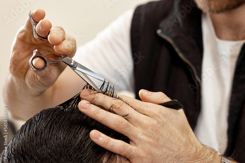 hairdresser does haircut for caucasian bearded man