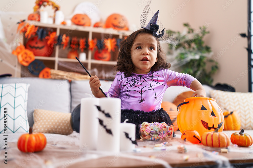 Fototapeta premium Adorable hispanic toddler having halloween party standing at home