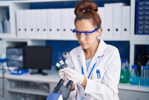 Young woman scientist holding samples working at laboratory