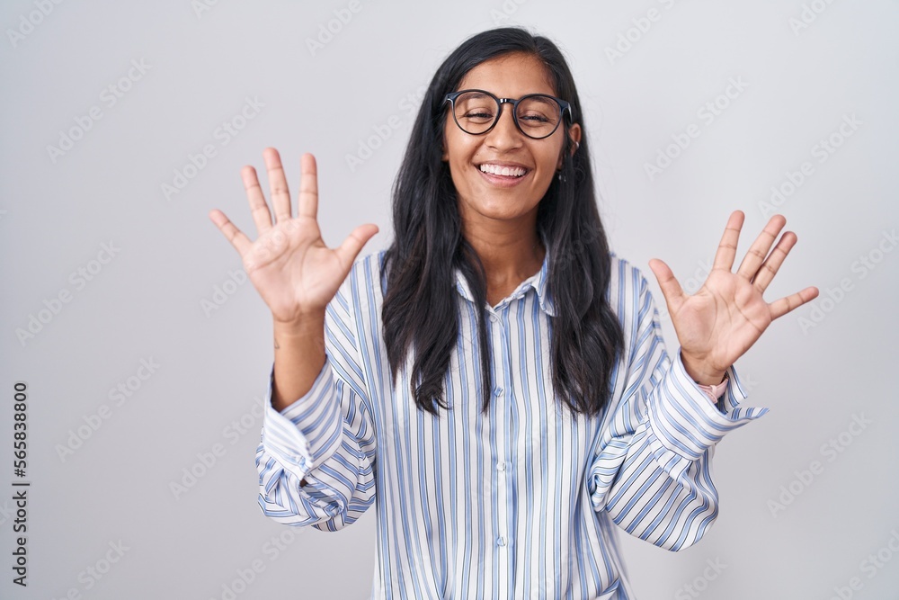 Young hispanic woman wearing glasses showing and pointing up with fingers number ten while smiling confident and happy. Young hispanic woman wearing glasses showing and pointing up with fingers number ten while smiling confident and happy.