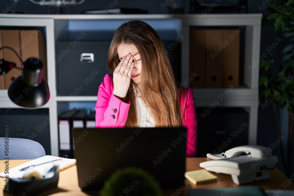 Obraz premium Young caucasian woman working at the office at night tired rubbing nose and eyes feeling fatigue and headache. stress and frustration concept.