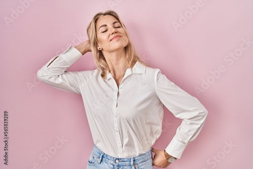 Young caucasian woman wearing casual white shirt over pink background stretching back, tired and relaxed, sleepy and yawning for early morning © Krakenimages.com