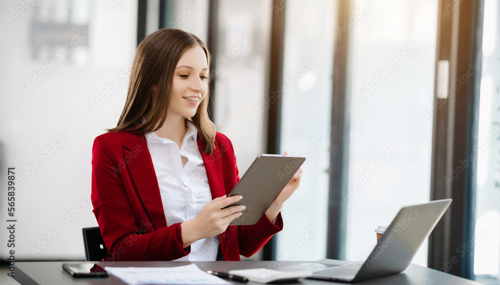 Confident Asian woman with a smile standing holding notepad and tablet at the modern office. Confident Asian woman with a smile standing holding notepad and tablet at the modern office.