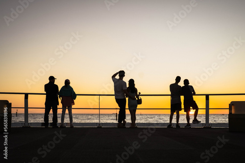 Couples Watching Sunset Over the Ocean From a Pier 