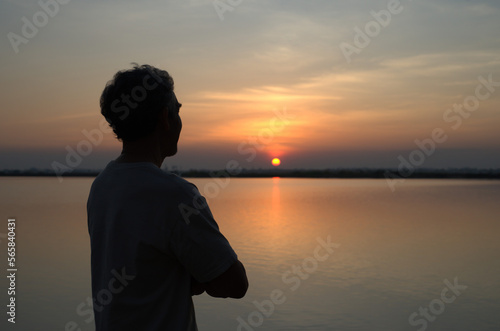 healthy mature man after exercise, resting,relaxing,standing by the pond and looking at sunset © Verin