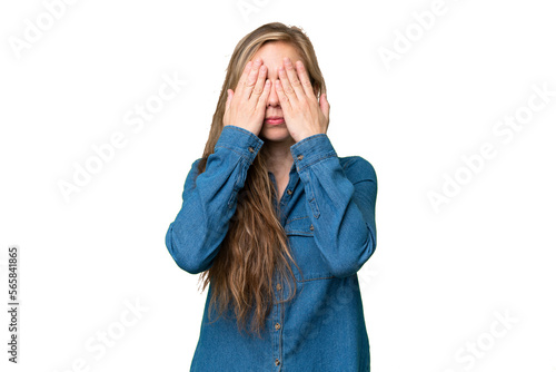 Young blonde woman over isolated background covering eyes by hands