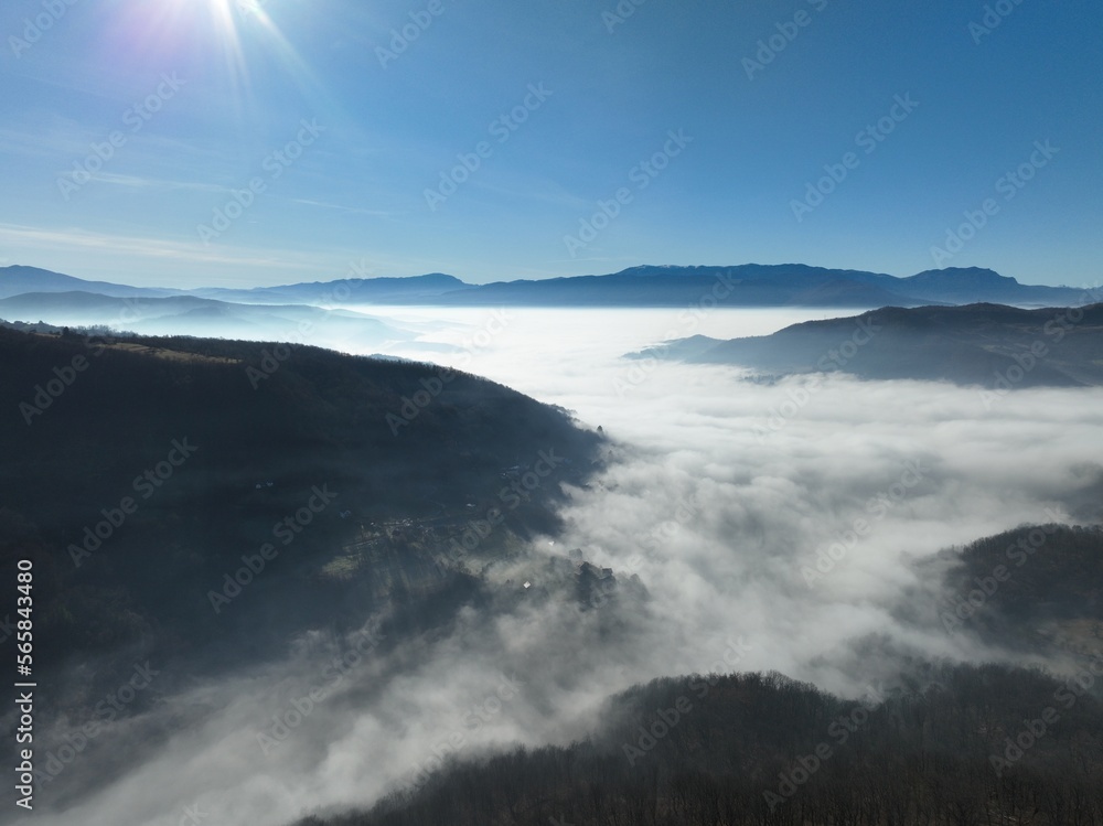 Aerial View. Flying over the high mountains in beautiful clouds. Aerial Drone camera shot. Air pollution clouds over Sarajevo in Bosnia and Herzegovina. 