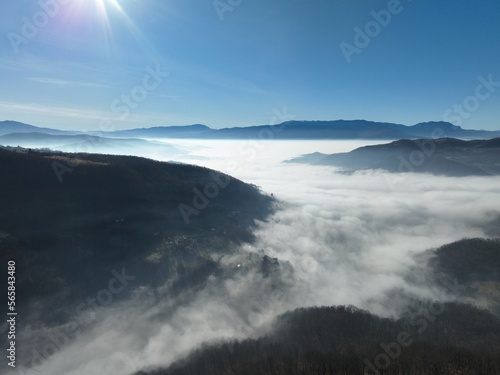 Aerial View. Flying over the high mountains in beautiful clouds. Aerial Drone camera shot. Air pollution clouds over Sarajevo in Bosnia and Herzegovina. 