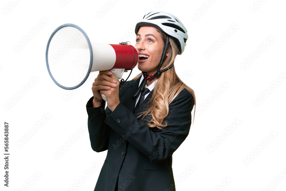 Business Uruguayan woman wearing a helmet biker over isolated background shouting through a megaphone Business Uruguayan woman wearing a helmet biker over isolated background shouting through a megaphone