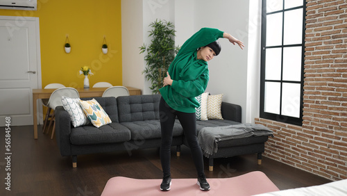 Fotografie Young chinese woman stretching at home