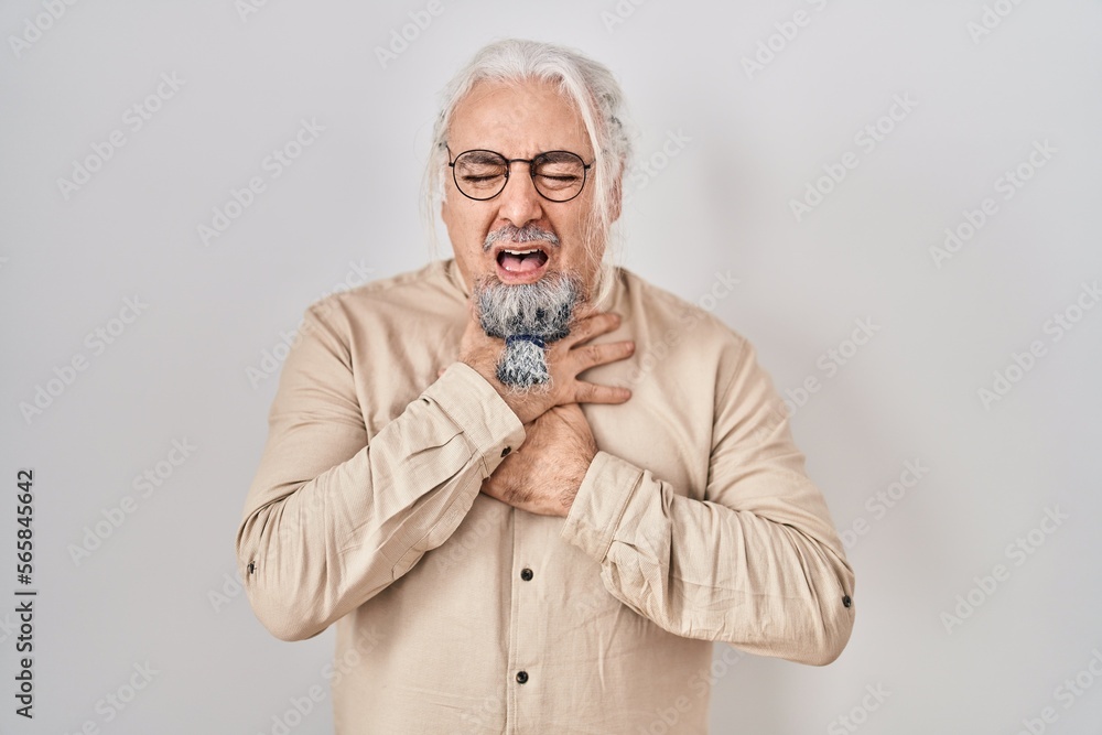 Middle age man with grey hair standing over isolated background shouting and suffocate because painful strangle. health problem. asphyxiate and suicide concept. Middle age man with grey hair standing over isolated background shouting and suffocate because painful strangle. health problem. asphyxiate and suicide concept.